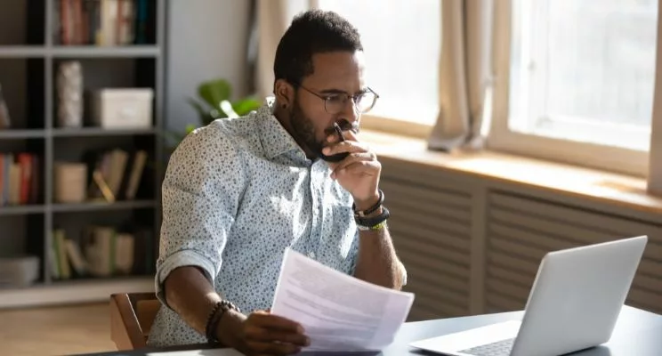 African american man looking confused at computer screen